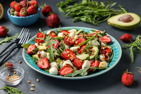 strawberry, avocado, rocket and mozzarella salad, dressed with olive oil and balsamic dressing